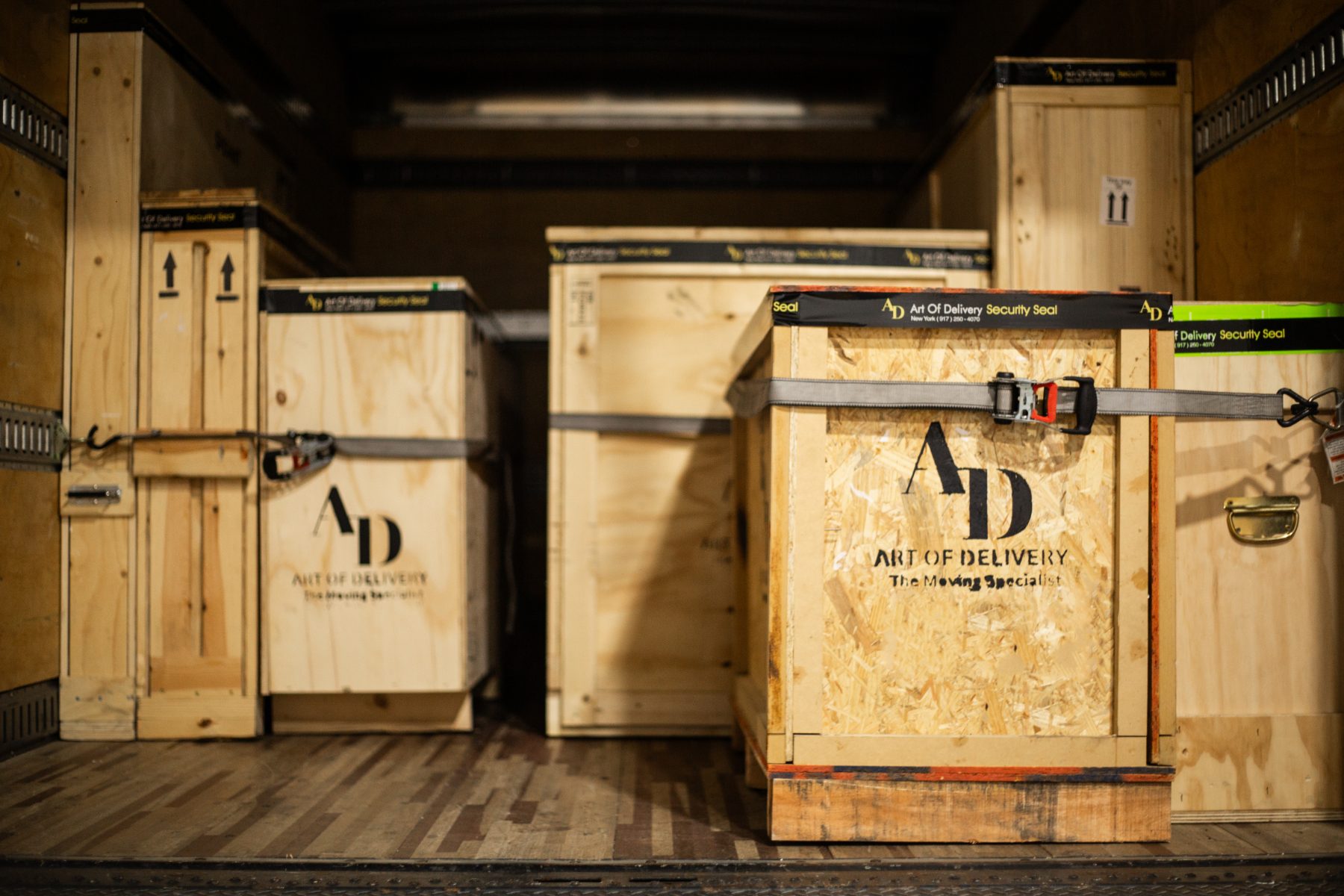 Sealed Art of Delivery crates strapped inside a truck